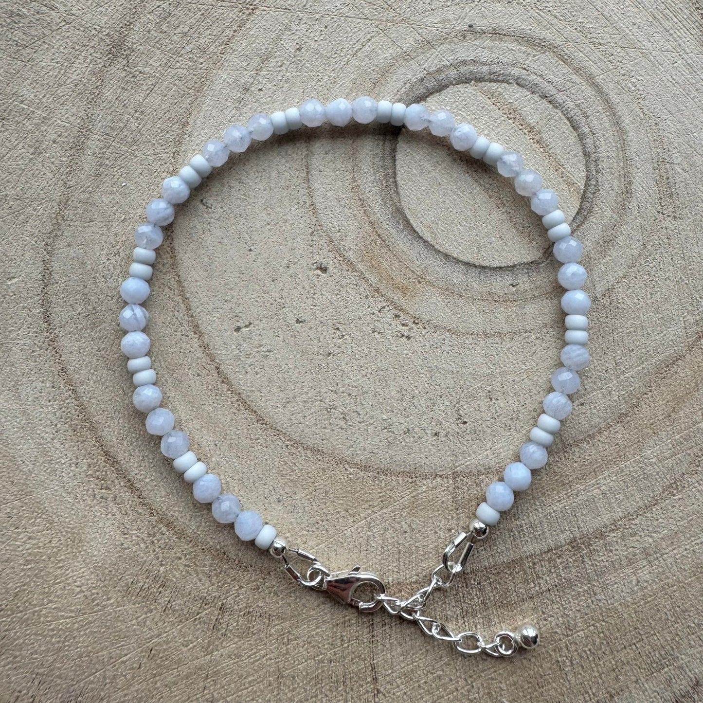 Pale blue gemstone beaded bracelet on wooden background