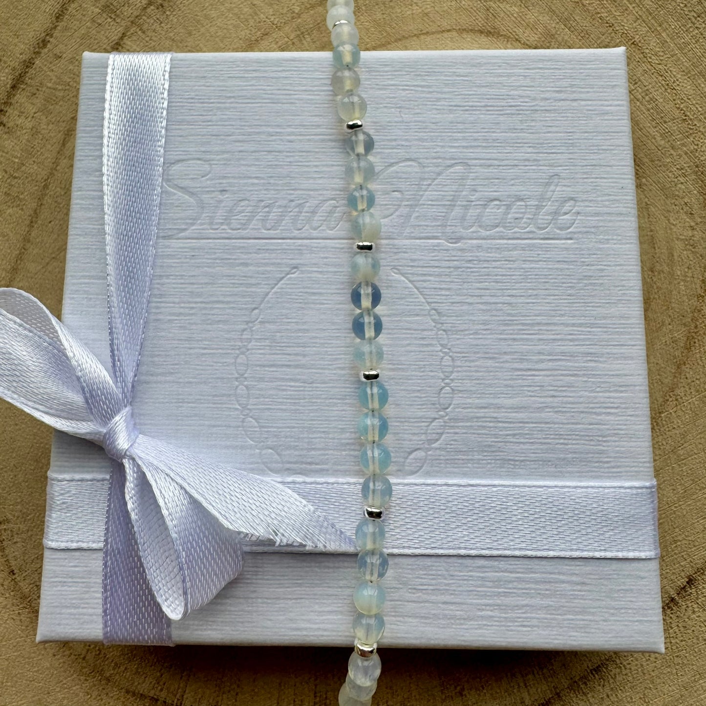 Vertical view of sterling silver opalite bracelet on gift packaging