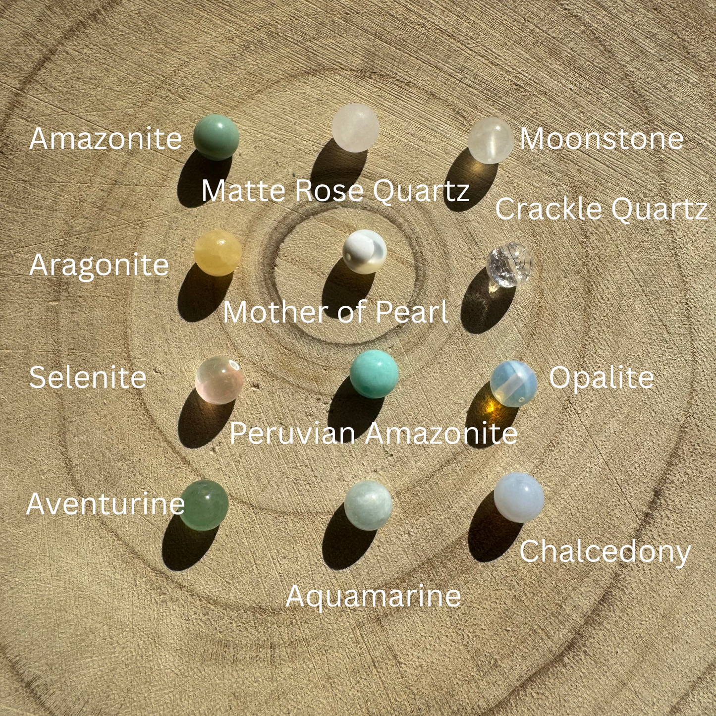 multiple labelled gemstone options on a wooden background to customise your own earrings