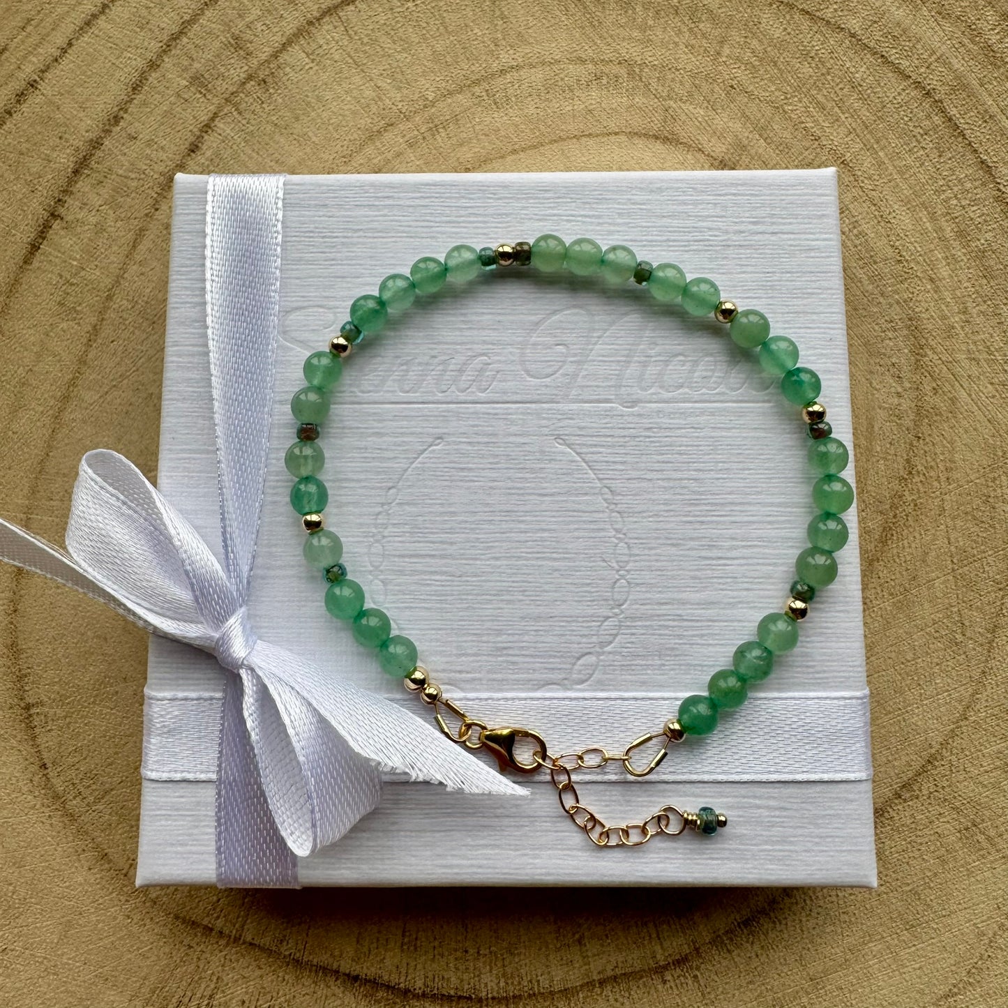 Green Aventurine bracelet with gold filled components on white gift packaging with a white ribbon
