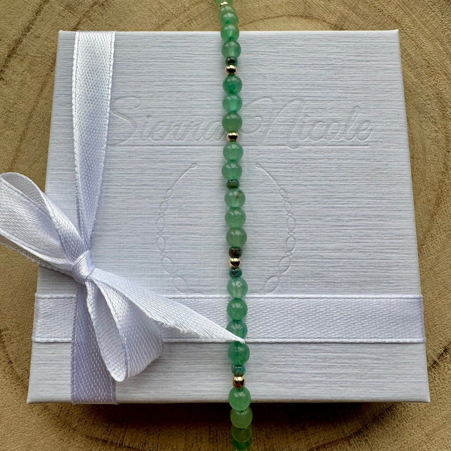 Vertical view of Green Aventurine Bracelet on gift packaging
