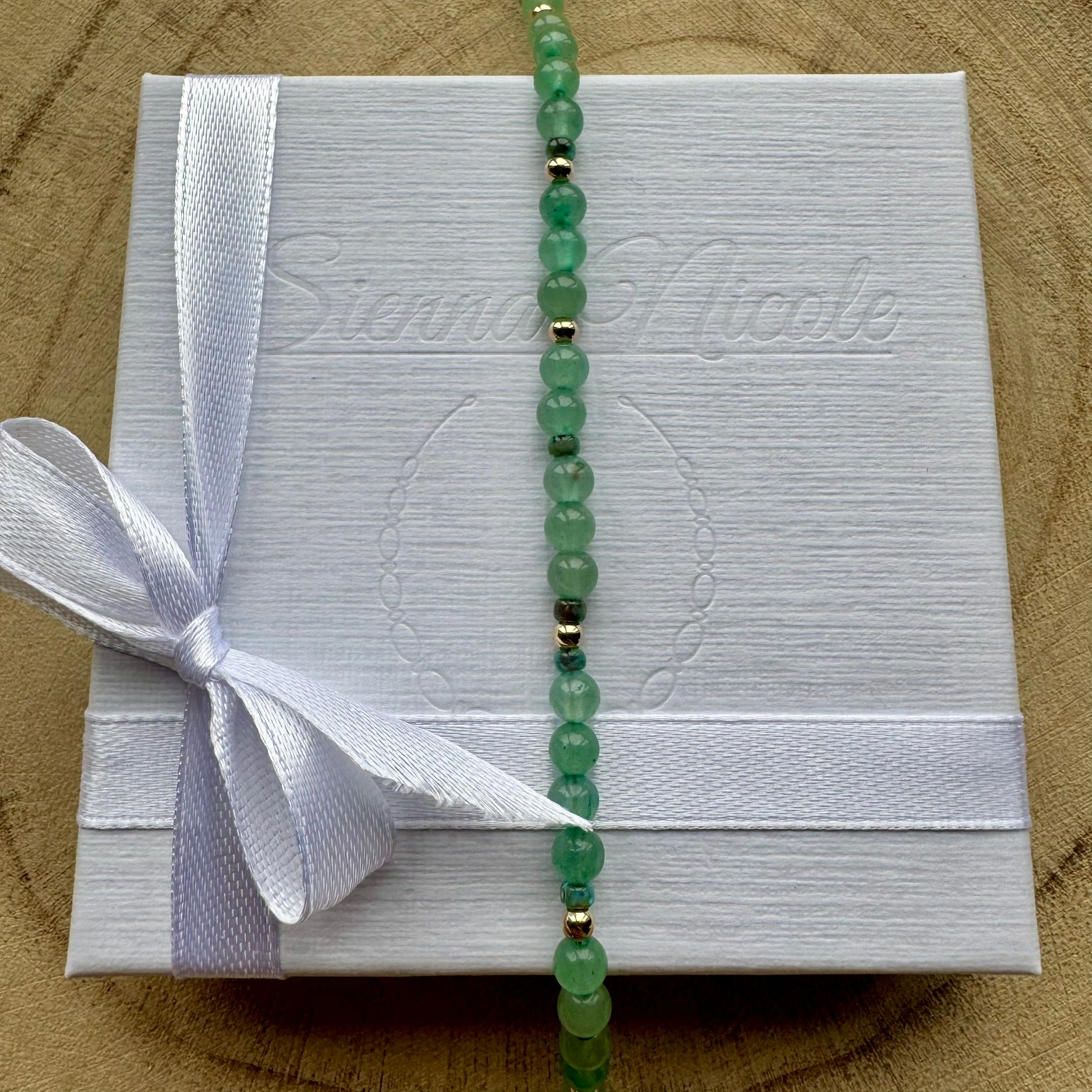 Vertical view of Green Aventurine Bracelet on gift packaging