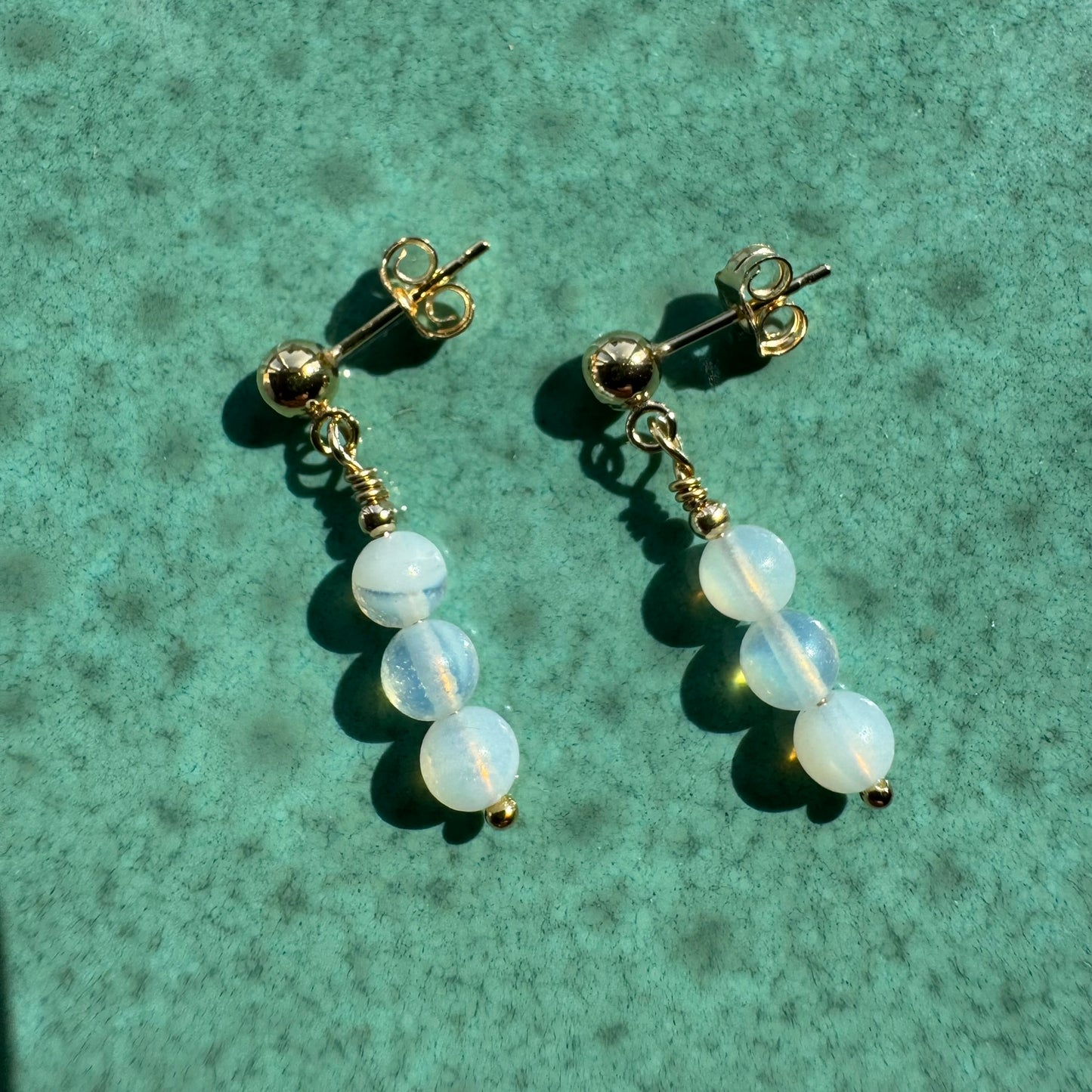 Pair of Gold filled opalite earrings on ceramic surface