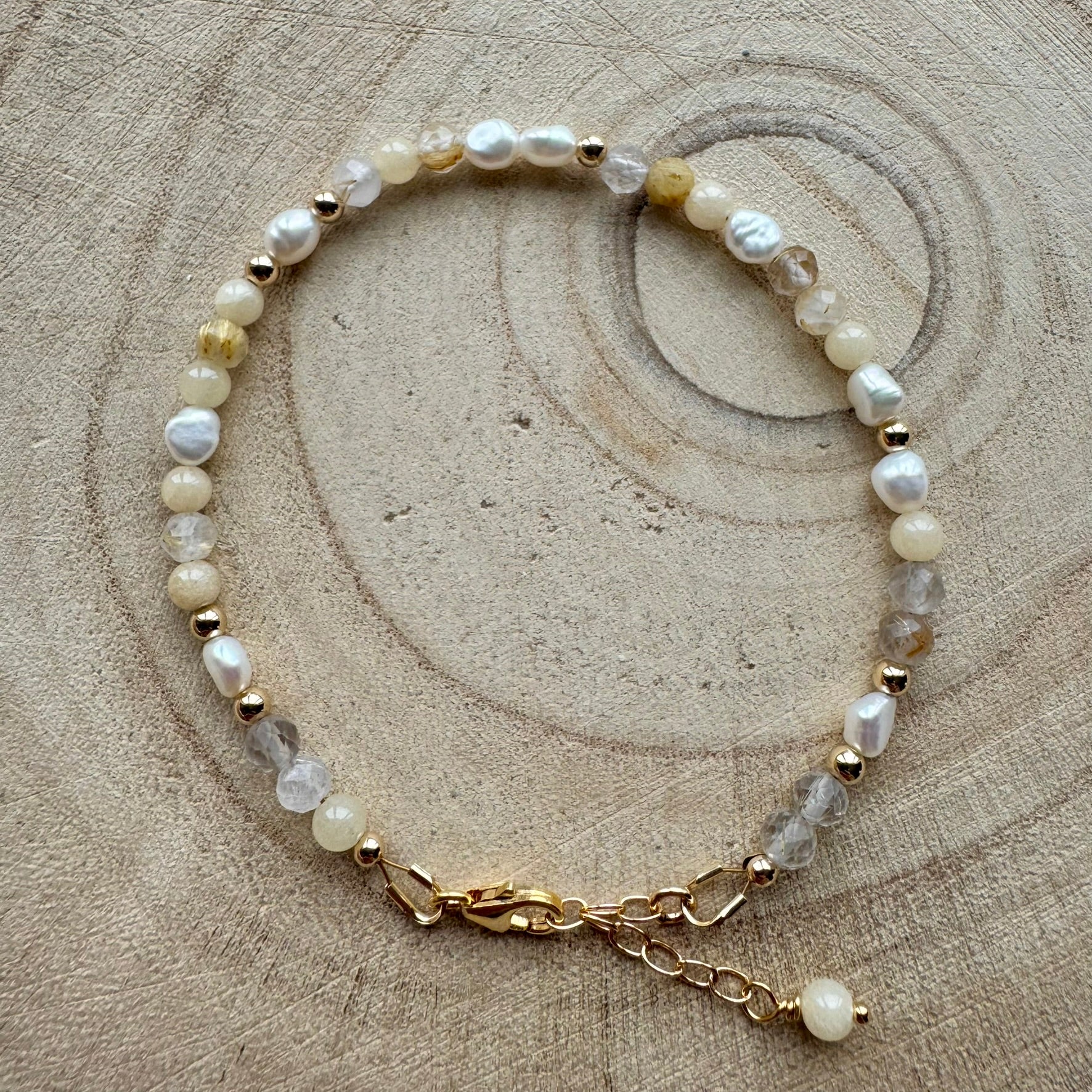 Pearl and mixed gemstone bracelet with gold filled details on wooden surface