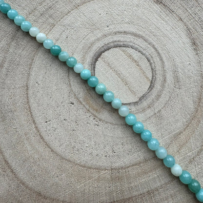 Blue green amazonite gemstone bracelet on a wooden background