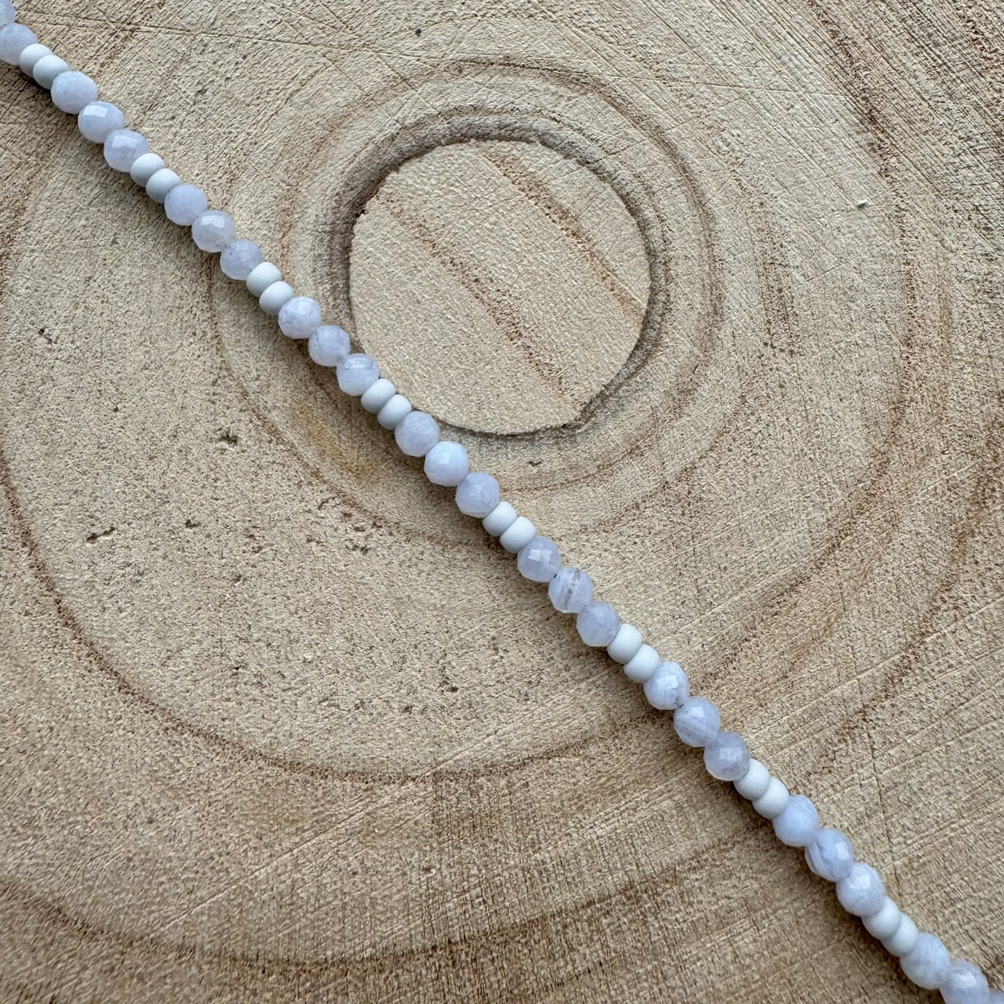 Pale blue gemstone beaded bracelet on wooden surface