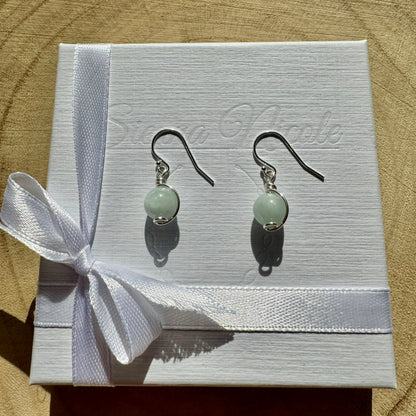 Pair of sterling silver drop gemstone earrings on a white box with a ribbon.