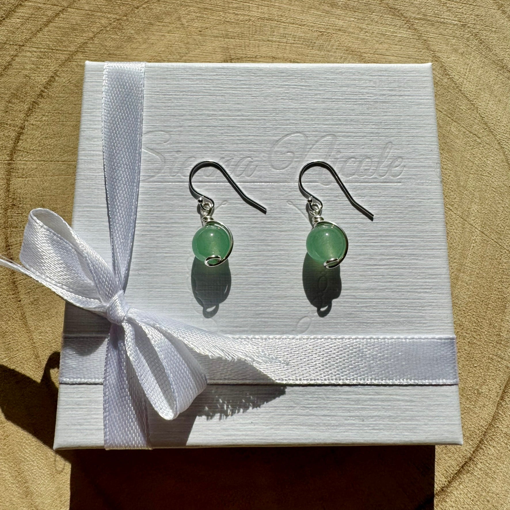 Sterling Silver and Green Aventurine Gemstone drop earrings on a white box with a white ribbon