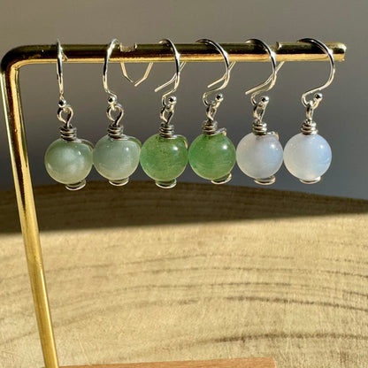 Set of Sterling Silver drop earrings with green aventurine, blue aquamarine and blue chalcedony gemstones on a gold stand.