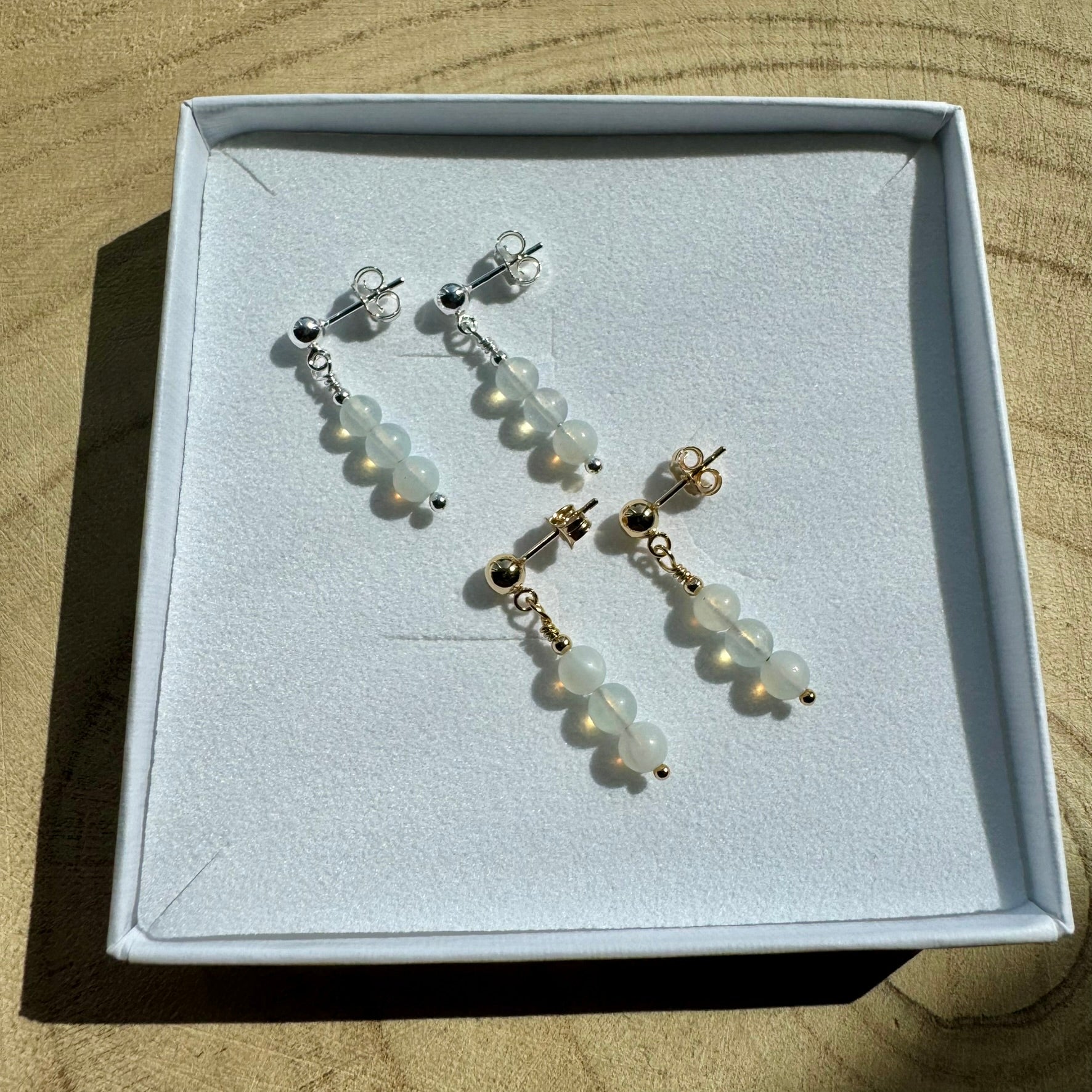 Image showing the same opailte earrings, one pair in sterling silver and one is gold filled