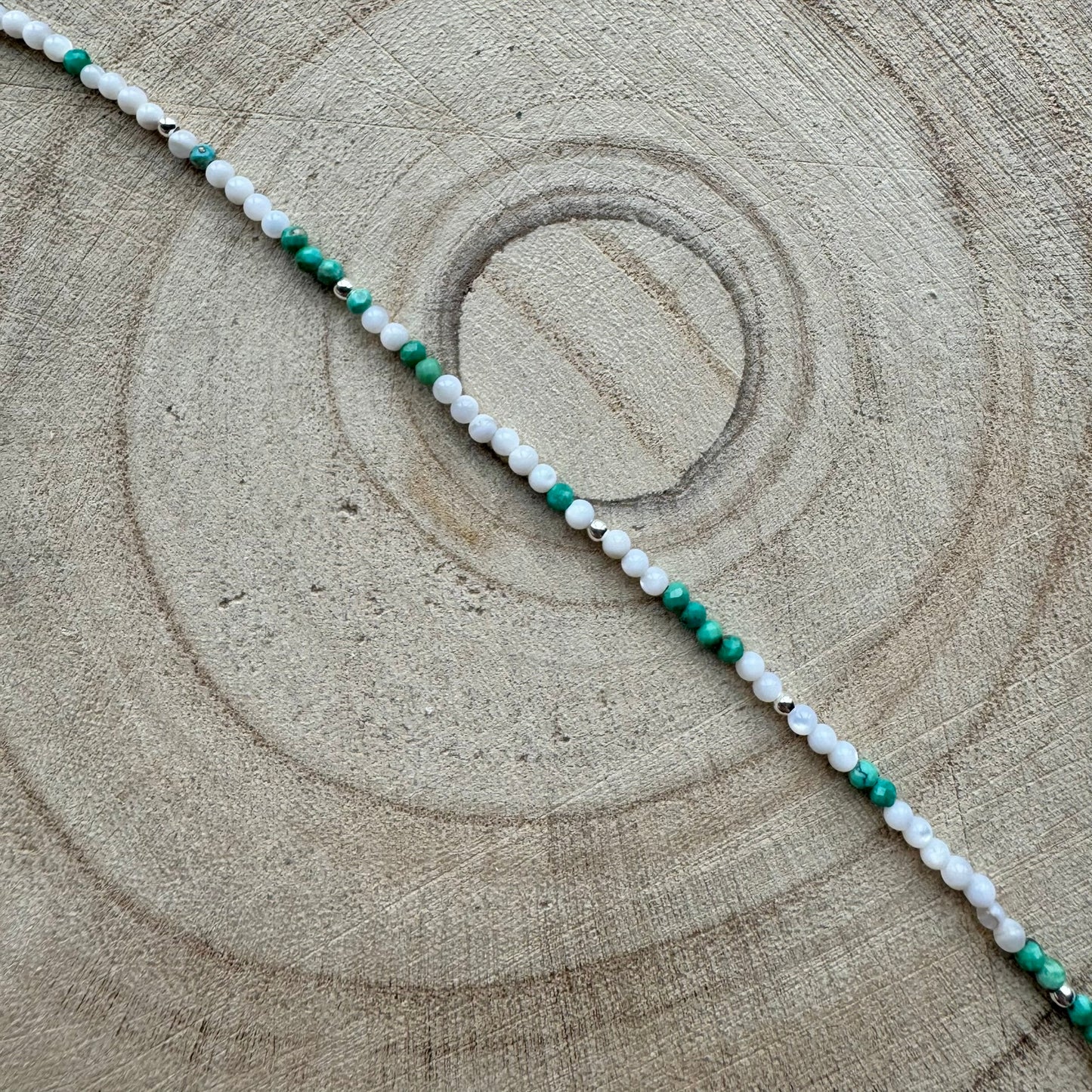 Mother of Pearl and turquoise bracelet on a wooden surface