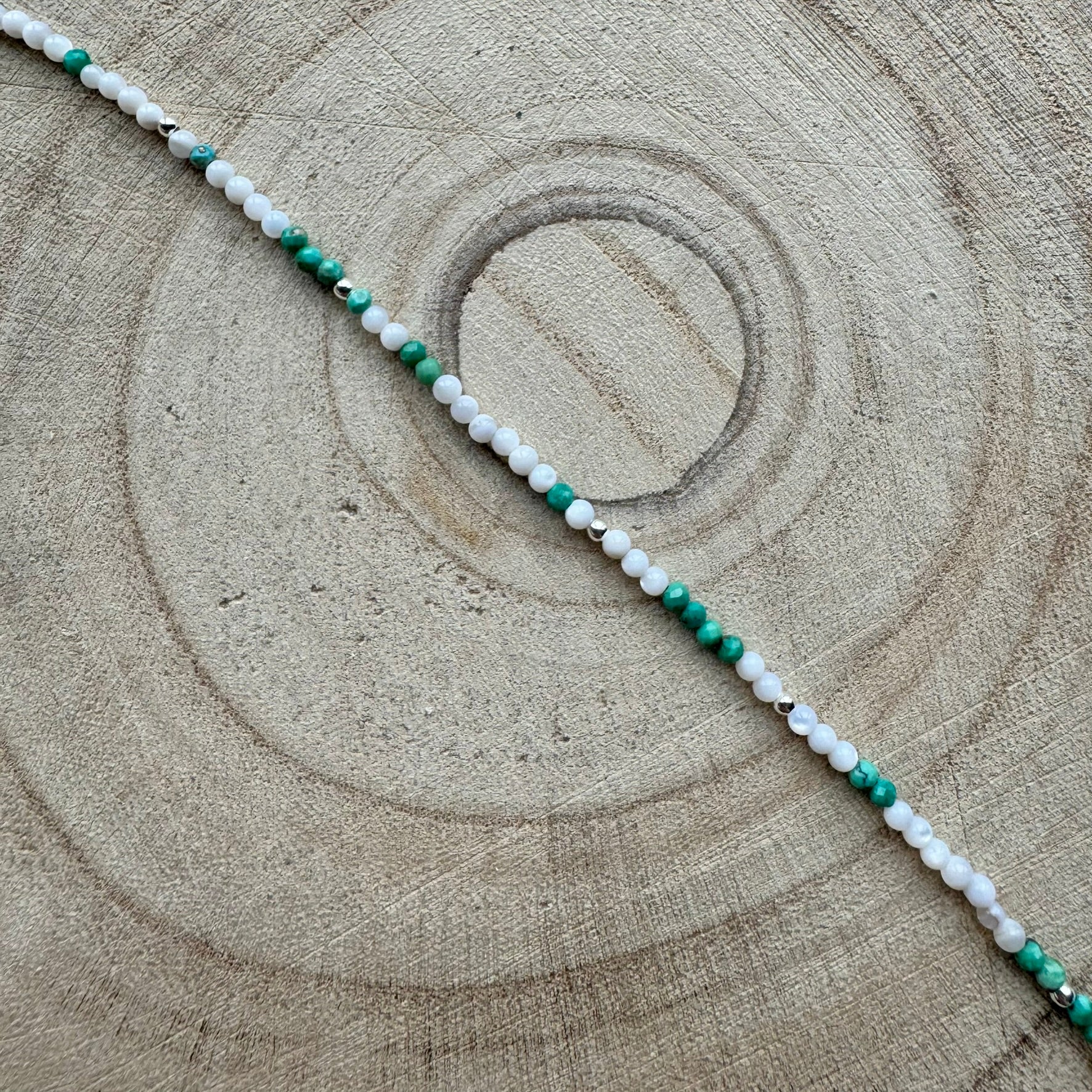 Mother of Pearl and turquoise bracelet on a wooden surface