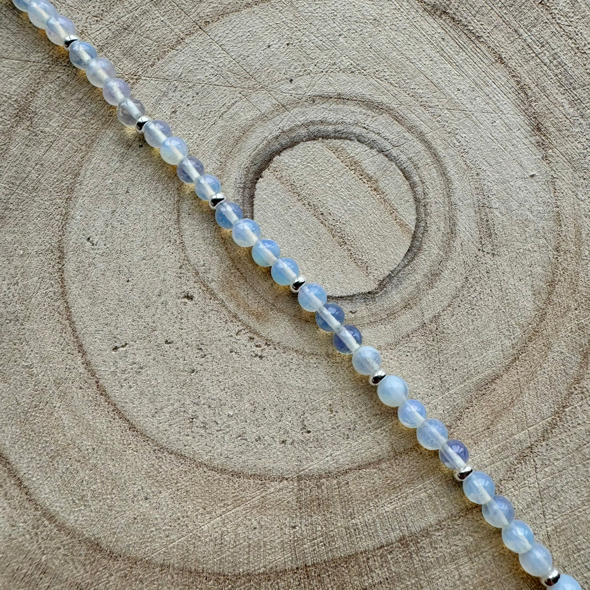 Close up of sterling silver opalite bracelet on wooden surface