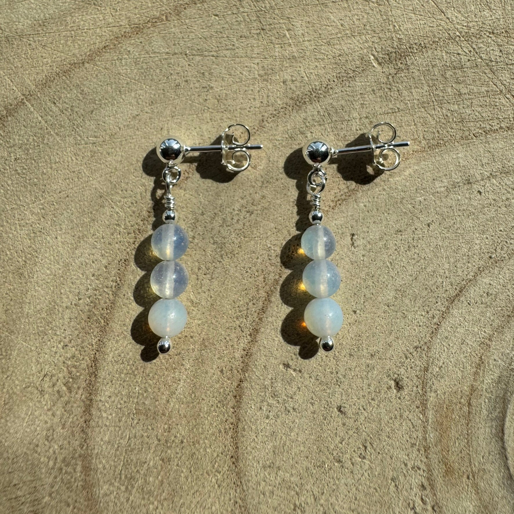 Pair of Sterling silver opalite earrings on wooden surface