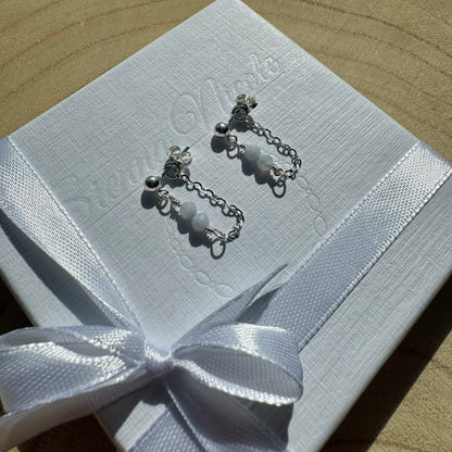 Pair of sterling silver chain earrings with blue chalcedony beads on gift packaging close up